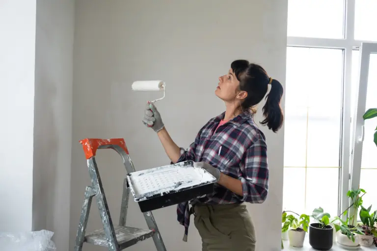 Woman painting a wall white