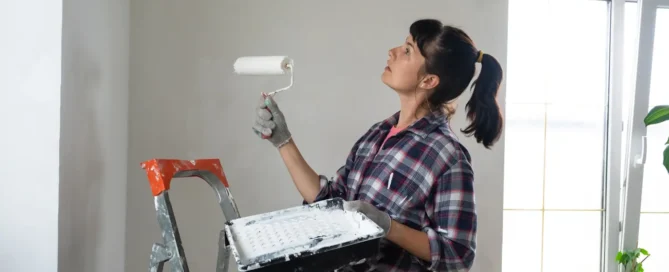 Woman painting a wall white