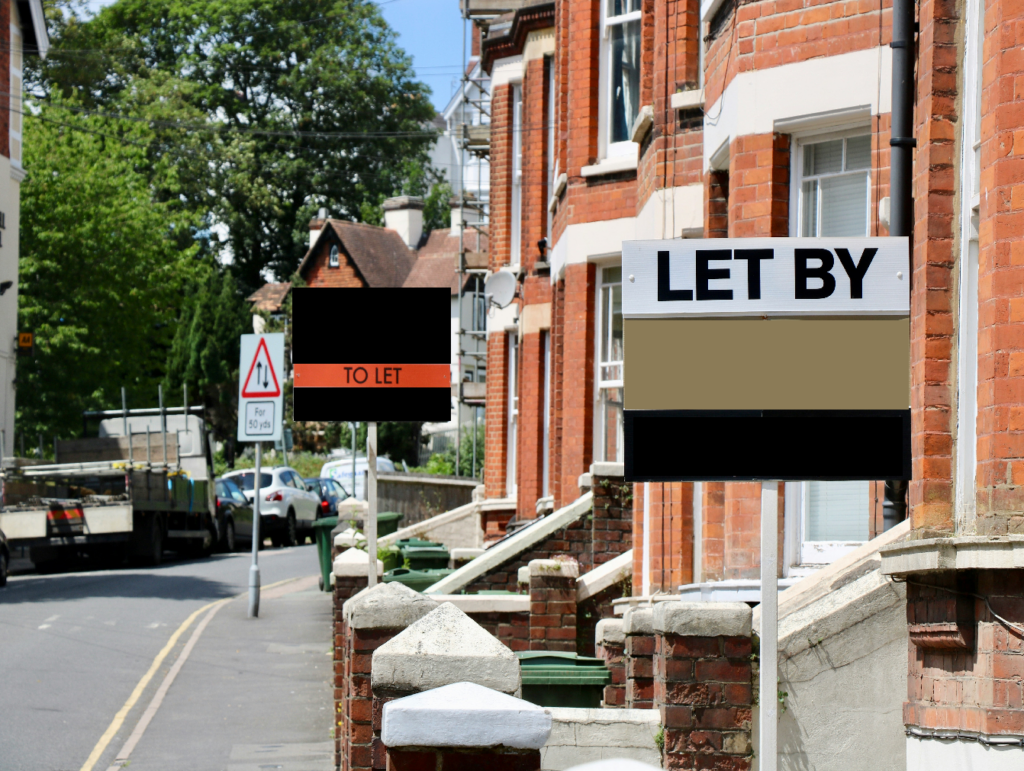 A residential street with red-brick houses displays two signs related to rental properties. The sign in the foreground reads "LET BY" indicating the property is rented out, while a sign in the background reads "TO LET" indicating a property available for rent.
