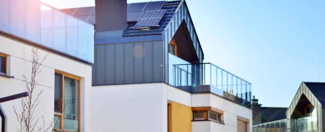 Modern home with solar panels on the roof under clear blue sky.