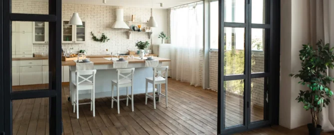 Bright staged kitchen with white cabinets, wooden worktops, and breakfast bar