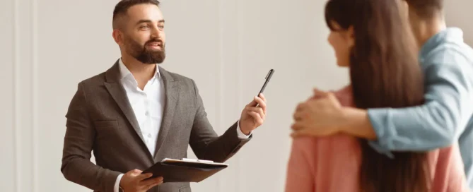 Professional estate agent conducting property viewing with couple in modern rental property