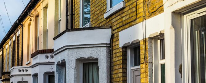 Traditional British terraced houses with yellow brick facades and individual front door entrances