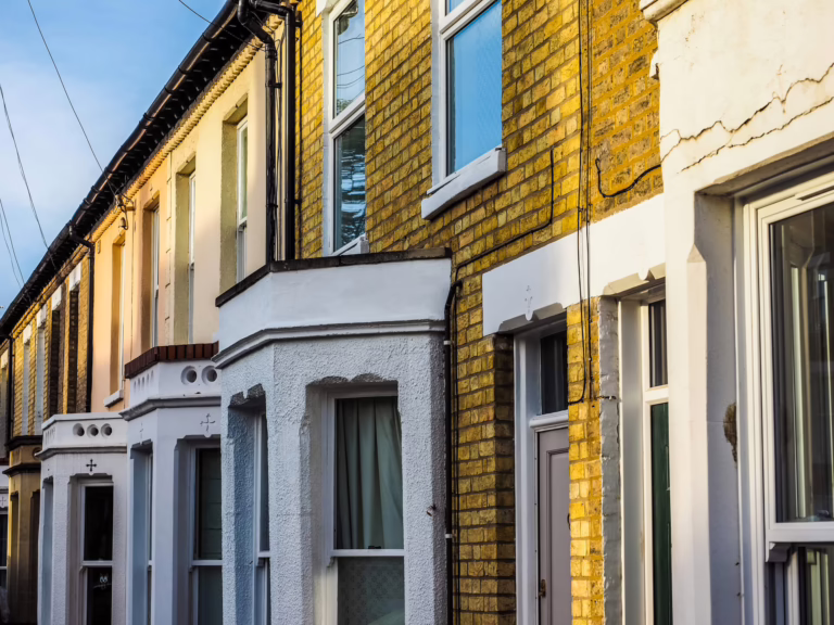 Traditional British terraced houses with yellow brick facades and individual front door entrances