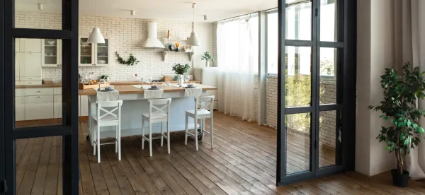 Bright staged kitchen with white cabinets, wooden worktops, and breakfast bar