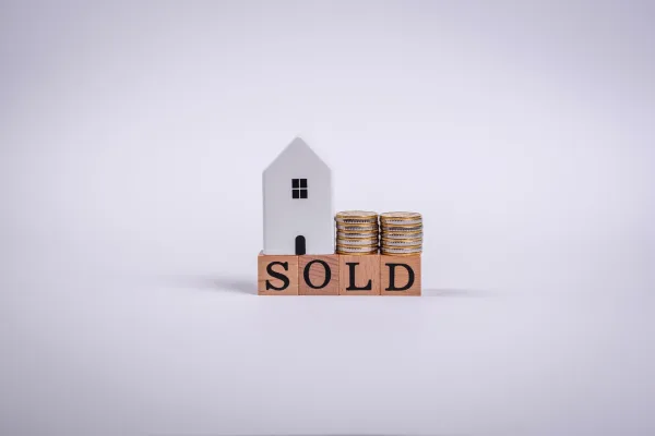 Quick house sale costs - house model with SOLD sign and money